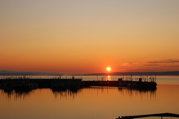 Naklejka na ściany i meble Sunset over fisher boats