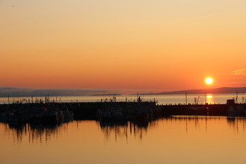 Sunset over fisher boats on a lake