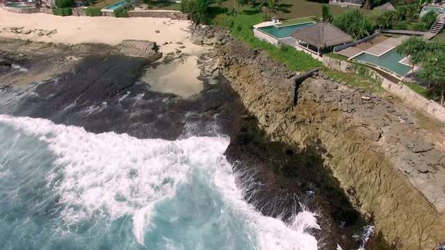 Rough ocean waves and strong current undertow surf from storm surge seen in the suburban luxury neighborhood villa and resort bungalow backyard international property
