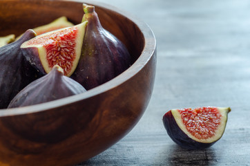 Ripe fig fruits are in the wooden bowl