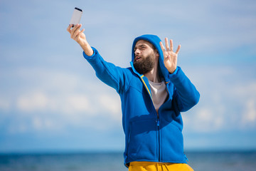 Naklejka premium hipster taking Selfie by the seaside 