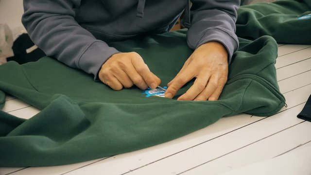 tailor applying logo on a sweatshirt.sewing, hand work, creativity