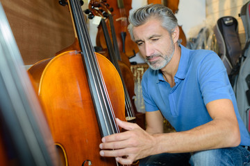 violin maker while testing the violins in his workshop