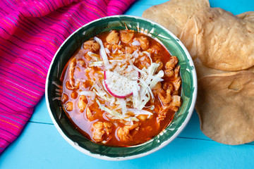 Mexican red pozole soup on blue background