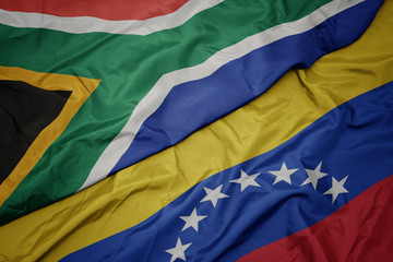 waving colorful flag of venezuela and national flag of south africa.