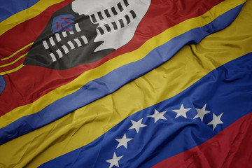 waving colorful flag of venezuela and national flag of swaziland.