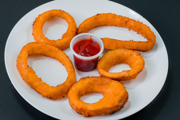 onion rings with cheese and red ketchup plus accompaniments