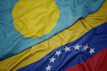 waving colorful flag of venezuela and national flag of Palau .