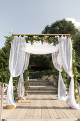 A festive chuppah decorated with fresh beautiful flowers for an outdoor wedding ceremony