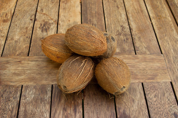 A Pile of whole coconuts on the wood table. Vegetarian and healthy food. Nutrition and diet background. Cosmetic industry.