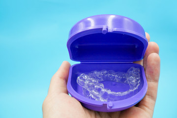 clear plastic retainer teeth in the box set isolated on blue sky background. it's an equipment for orthodontist give the patient to orthodontic surgery in dental clinic or hospital