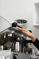 Barista girl is preparing aromatic coffee with a coffee machine. Barista work in a coffee shop