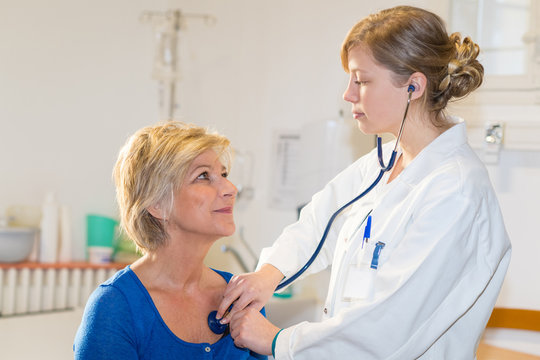 Female Doctor Checking On Female Patient Heart Rate