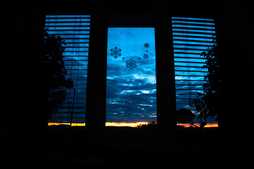 Beautiful dark blue-red sunset with clouds from the window of the house