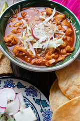 Mexican red pozole soup on wooden background