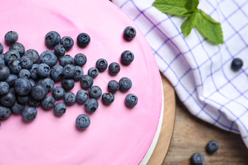 Board with tasty blueberry cake on wooden table, closeup