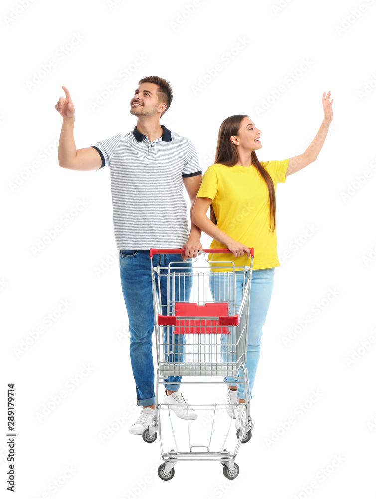 Canvas Prints Young couple with empty shopping cart on white background