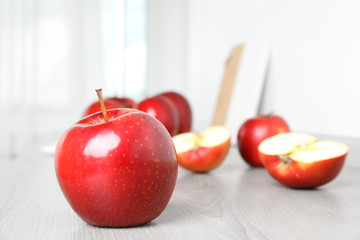 Ripe juicy red apples on white wooden table indoors