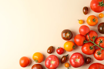 Flat lay composition with fresh ripe tomatoes on beige background. Space for text