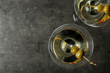 Glasses of Classic Dry Martini with olives on grey table, flat lay. Space for text