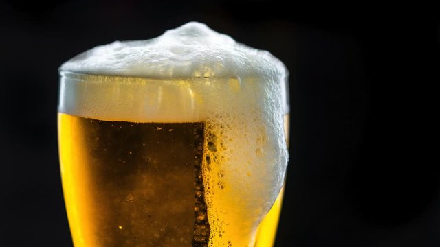 Cinemagraph of foaming glass of beer close up party and celebration