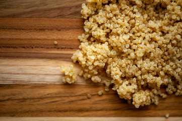 Rustic wooden board with cooked quinoa