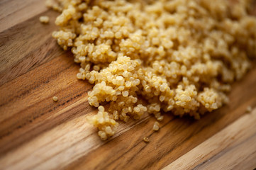 Cooked quinoa on rustic wooden board