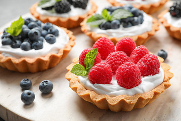 Different berry tarts on table, closeup. Delicious pastries