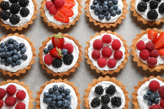 Different berry tarts on table, flat lay. Delicious pastries