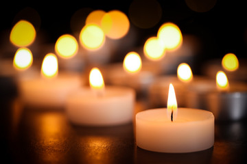 Fototapeta na wymiar Burning candles on table, closeup. Funeral symbol