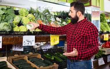 Young male seller offering cauliflowers
