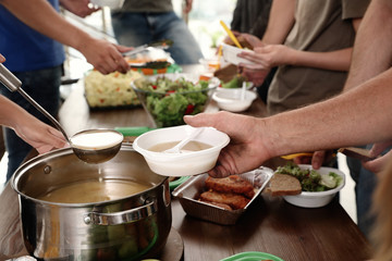 Volunteers serving food to poor people in charity centre