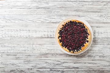 Berry pie with cherry, currant, blackberry, blueberry on white wooden table. Cheesecake, top view with copy space.