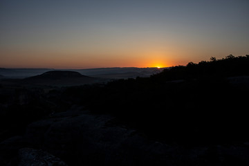 Dawn in the mountains. Mountain landscape. The sun rises from the horizon. Beautiful background early hours in the highlands. Bright rays shine from afar.