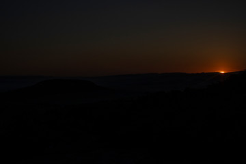 Sunset in the mountains. The beauty of sunset when viewed from the height of the mountains. Beautiful background of the awakening of the sun.
