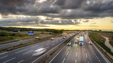 Colourful sunset at M1 motorway near Flitwick junction with blurry cars in United Kingdom