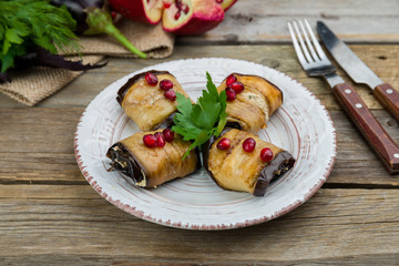 Eggplant rolls stuffed with nuts on old wooden table