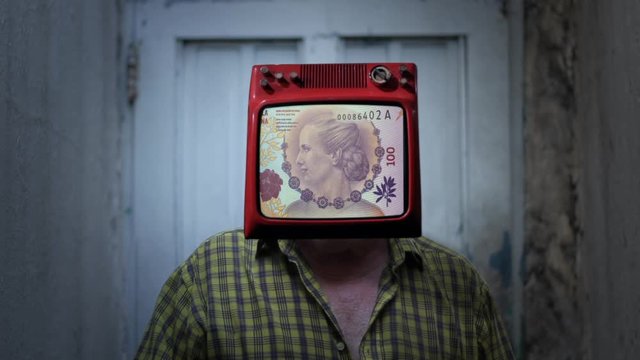 Argentine Peso with Evita&acute;s Face in the TV Head of a Man. TV on the Head of a Man. Money Addiction Concept. 