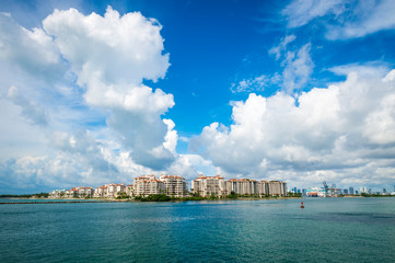 Bright sunny view of the Miami skyline with tropical clouds above calm seas at Government Cut in...