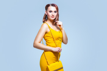 Fashion Caucasian Female Posing in yellow Dress and Purse.