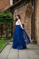 Portrait of Sensual Young Brunette Lady Dancing in Long Blue Dress. Wearing Tiara.