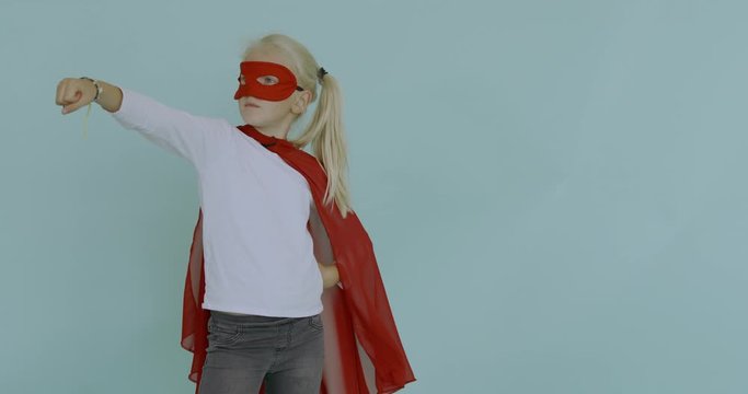 120 FPS SLOW MOTION Cute little Caucasian girl wearing red cape and mask, pretending to be a superhero. 4K UHD