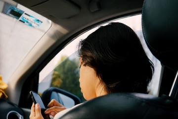 woman in a car with her phone