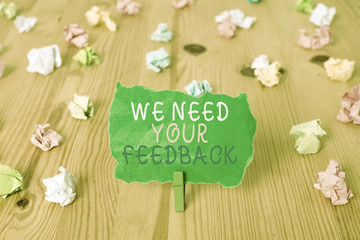 Word writing text We Need Your Feedback. Business photo showcasing criticism given to say can be done improvement Colored crumpled papers empty reminder wooden floor background clothespin