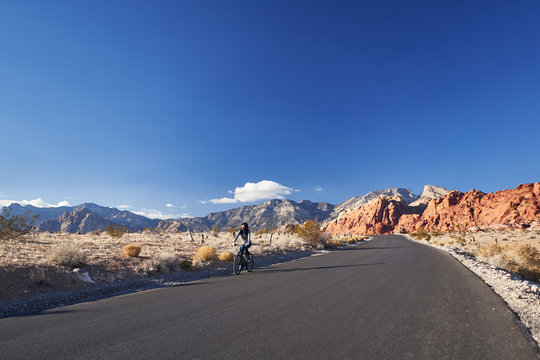 african american woman riding bicycle through red rock canyon park