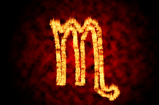 Astrology and horoscope conceptual idea with the fiery astrological sign of the Scorpio in blazing fire flame isolated on black background with red cloud