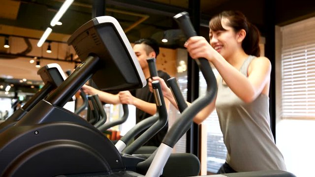 一緒にクロストレーナーで運動をするカップル