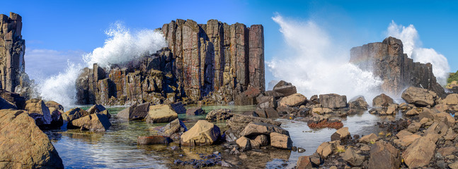 Panorama of waves breaking over basalt rock formations and rockpools at Bombo Headland quarry, New...