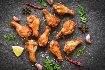 Fried chicken wings with lemon garlic chilli herbs and spices on black plate top view - Baked chicken wings BBQ