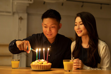 フルーツケーキで誕生日を祝う若いカップル